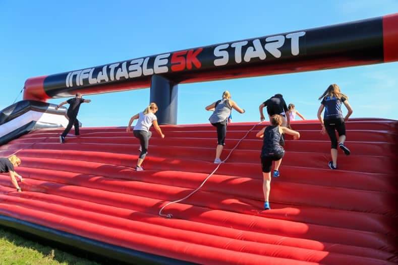 image of people running up an inflatable 5km